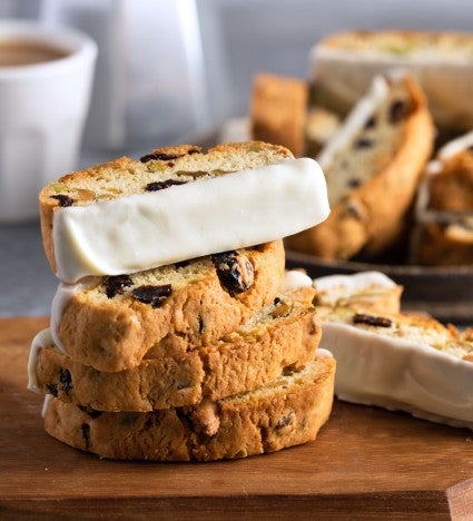 Cranberry-pistachio biscotti dipped in white chocolate on a serving plate.